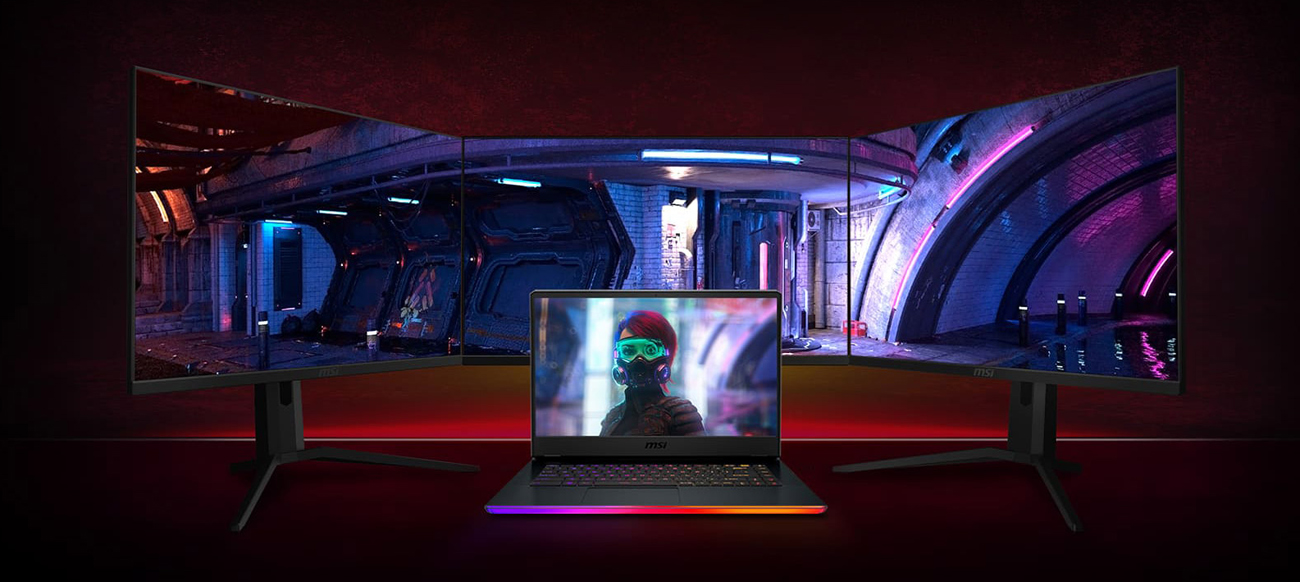 An opened GE66 Raider laptop has three monitor behind it